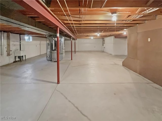 unfinished basement with heating unit and a sink