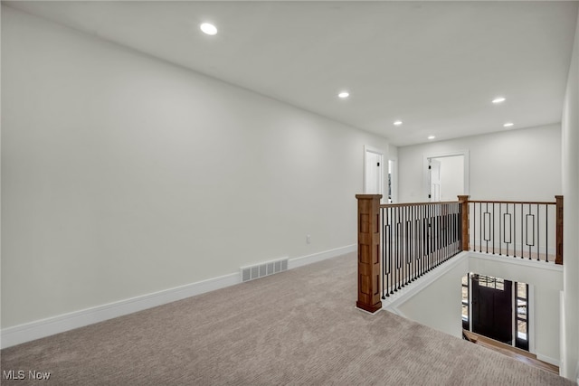 interior space with visible vents, baseboards, recessed lighting, carpet flooring, and an upstairs landing