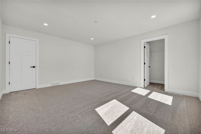 empty room featuring carpet flooring, recessed lighting, visible vents, and baseboards