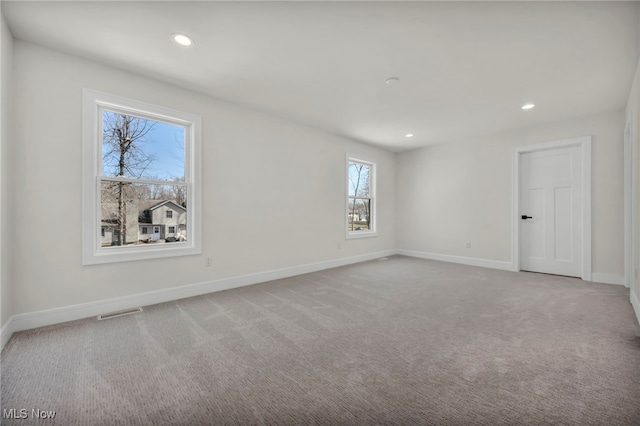 carpeted empty room featuring visible vents, recessed lighting, and baseboards