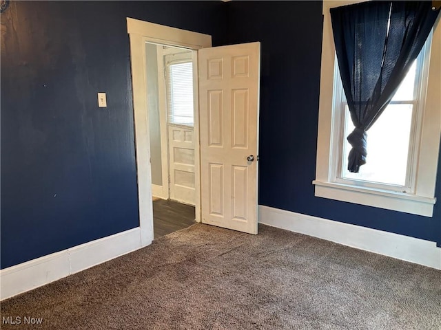empty room with baseboards and carpet floors