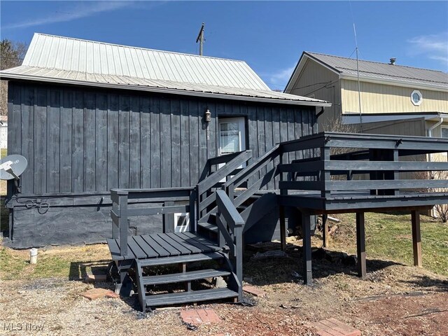 rear view of property featuring a wooden deck and metal roof
