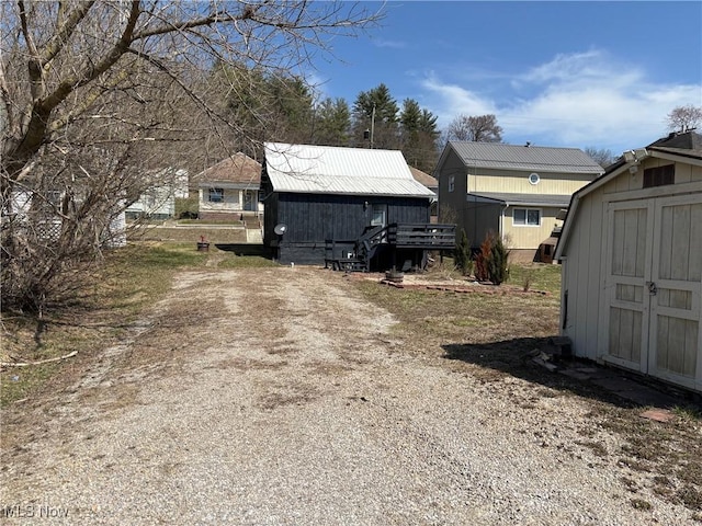 exterior space with an outdoor structure, a shed, and driveway
