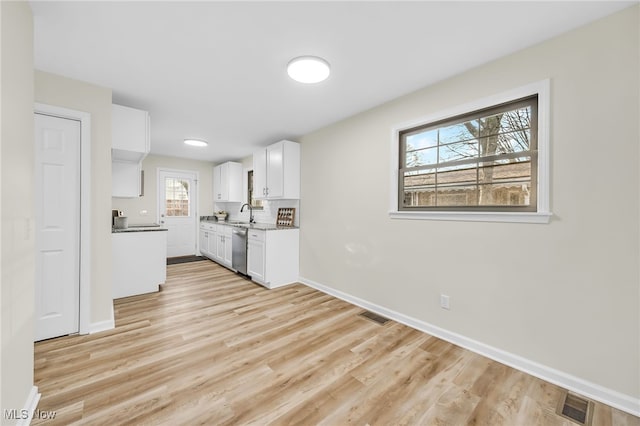 kitchen featuring dishwasher, light wood-style floors, baseboards, and white cabinetry