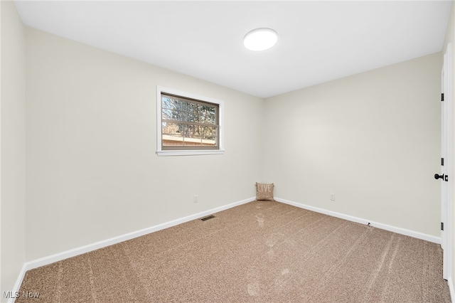 empty room featuring visible vents, baseboards, and carpet floors