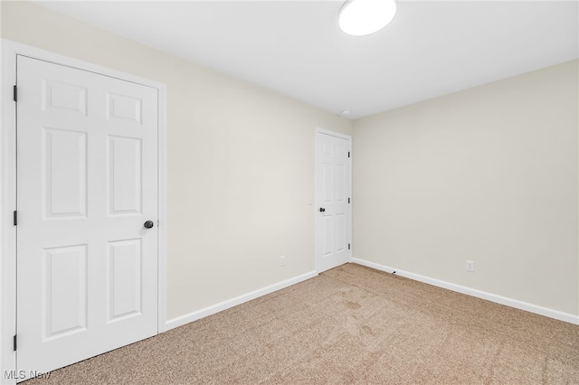 carpeted spare room featuring baseboards