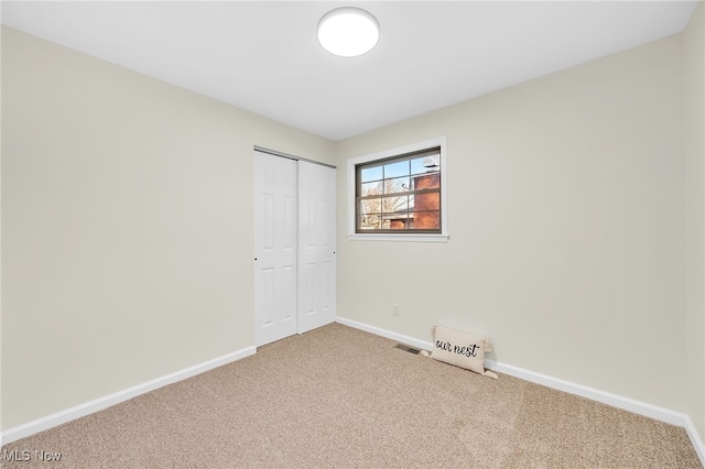 unfurnished bedroom featuring a closet, baseboards, and carpet