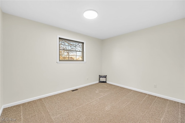 unfurnished room with visible vents, baseboards, and carpet floors