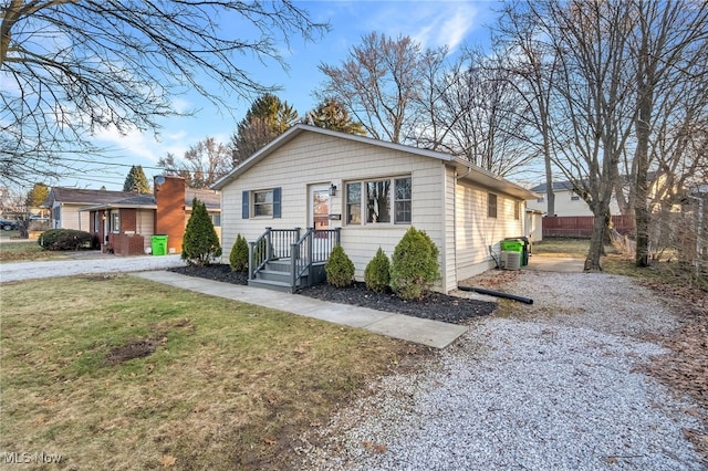 view of front of home with a front lawn and fence