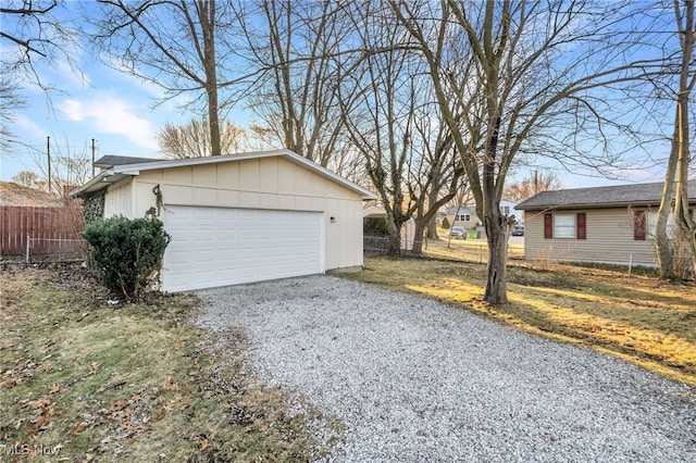 garage featuring fence and driveway