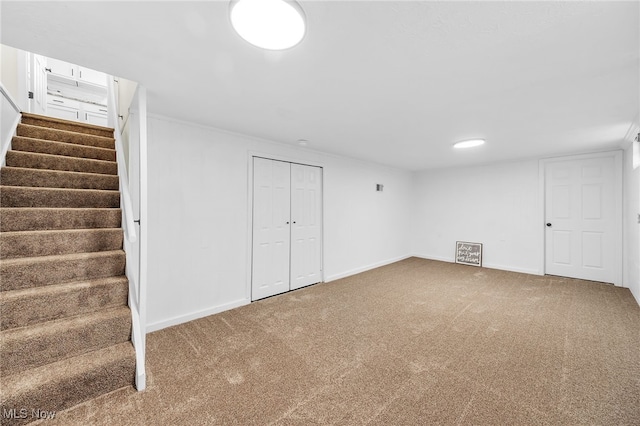 finished basement featuring stairway, carpet, and baseboards