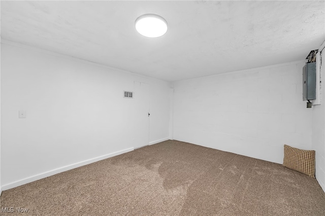 carpeted spare room featuring electric panel, visible vents, and baseboards