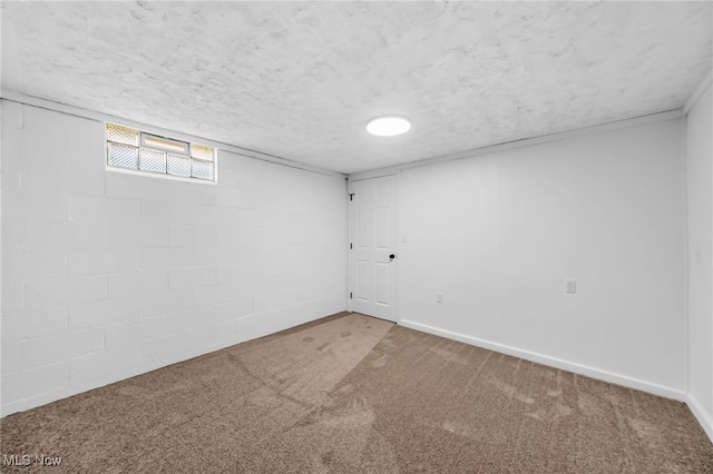 basement featuring baseboards, carpet floors, a textured ceiling, and concrete block wall