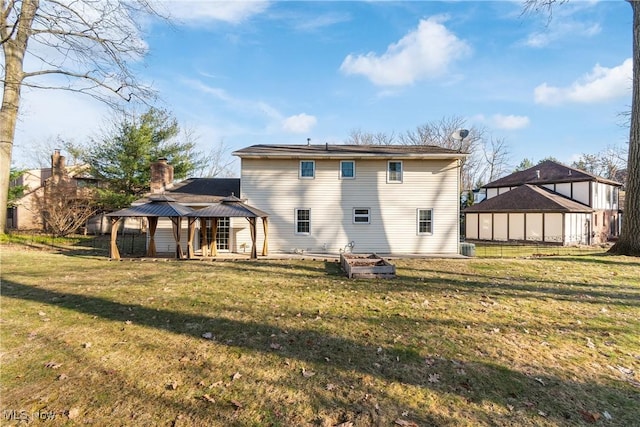 back of house with a gazebo, a lawn, and a chimney