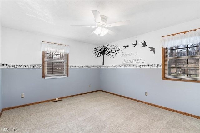 unfurnished room featuring visible vents, baseboards, a ceiling fan, and carpet floors