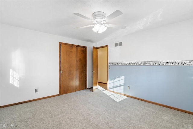 unfurnished room featuring visible vents, baseboards, carpet, and ceiling fan