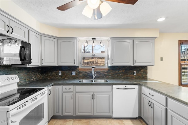 kitchen with tasteful backsplash, gray cabinetry, white appliances, a ceiling fan, and a sink