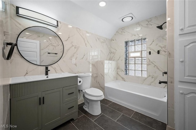 bathroom with toilet, vanity, vaulted ceiling, bathing tub / shower combination, and tile walls