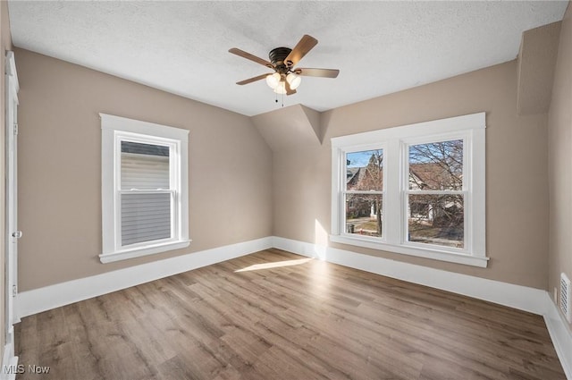 unfurnished room featuring baseboards, a textured ceiling, ceiling fan, and wood finished floors