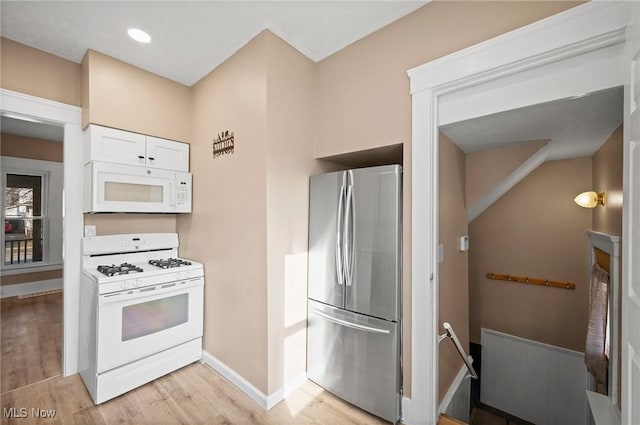 kitchen with baseboards, light wood-type flooring, recessed lighting, white cabinets, and white appliances