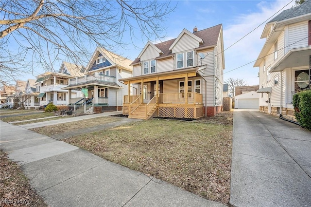 view of front of property with a residential view, covered porch, a detached garage, and an outdoor structure