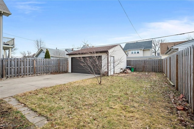 view of yard featuring an outbuilding, a fenced backyard, and a garage