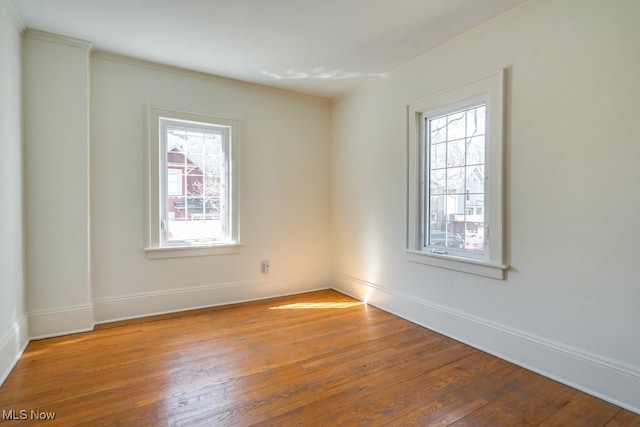 spare room featuring hardwood / wood-style flooring, a wealth of natural light, and ornamental molding