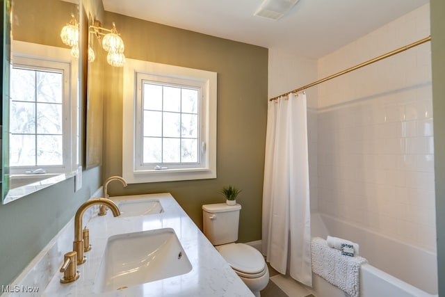 bathroom with visible vents, shower / bathtub combination with curtain, toilet, and a sink