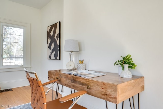 office area featuring wood finished floors, visible vents, and baseboards