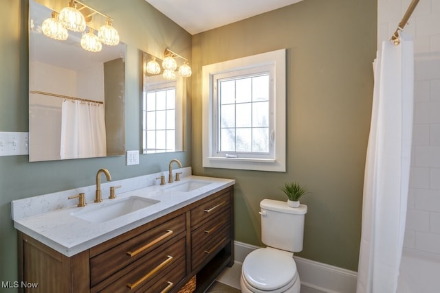 bathroom with a sink, a notable chandelier, and toilet