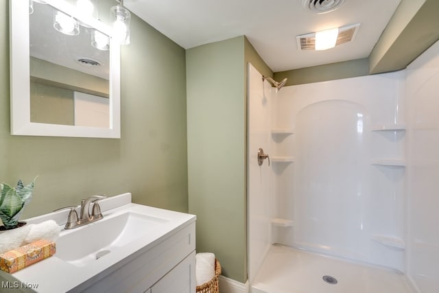 bathroom with visible vents, vanity, and a shower stall