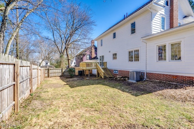 back of property featuring central air condition unit, a fenced backyard, a yard, stairway, and a chimney