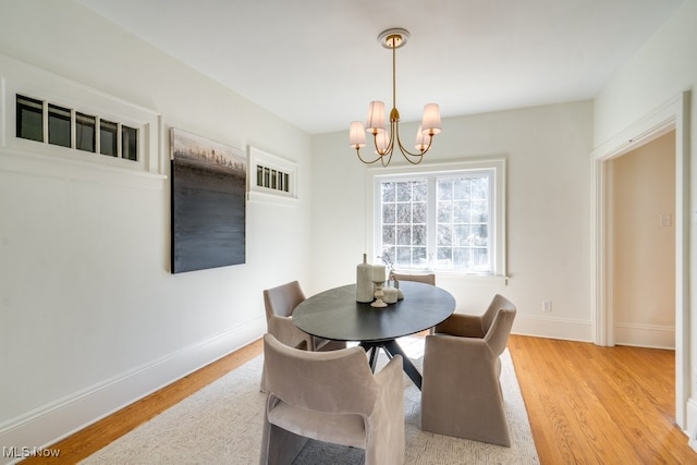 dining area with a notable chandelier, light wood-type flooring, and baseboards