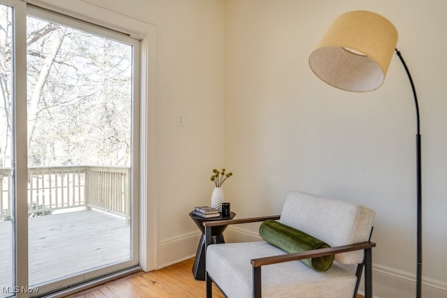 living area featuring a healthy amount of sunlight, light wood-style flooring, and baseboards