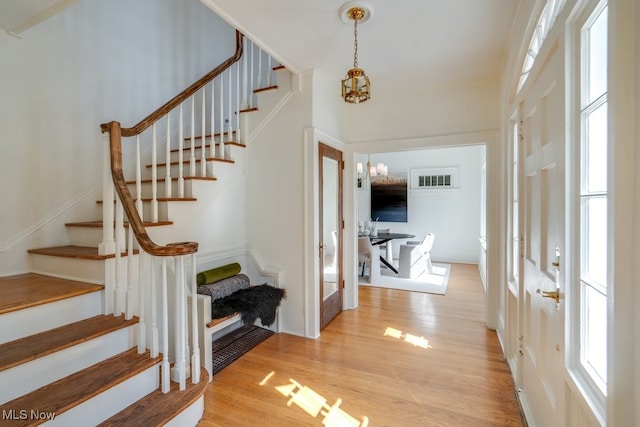 entrance foyer featuring stairway, wood finished floors, and a chandelier