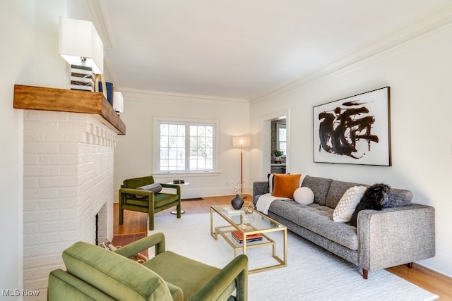 living room with wood finished floors, a fireplace, baseboards, and ornamental molding