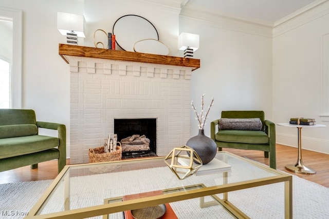 living room featuring baseboards, a fireplace, wood finished floors, and crown molding