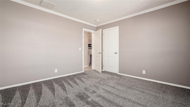 carpeted empty room with visible vents, baseboards, and ornamental molding