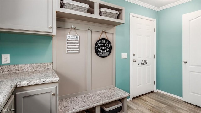 mudroom with baseboards, light wood-style floors, and ornamental molding