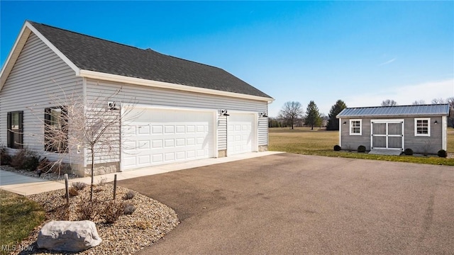 view of property exterior featuring aphalt driveway and an outdoor structure