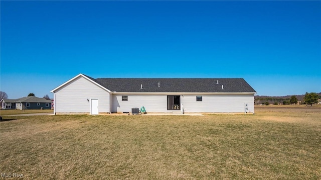 rear view of house featuring a lawn and cooling unit