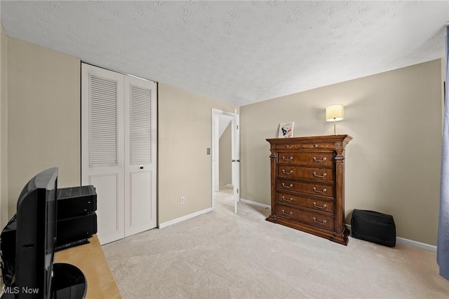 bedroom with a closet, a textured ceiling, and baseboards