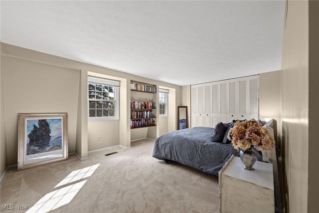 carpeted bedroom with baseboards and visible vents