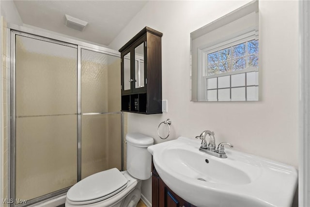 bathroom featuring visible vents, toilet, a stall shower, and vanity