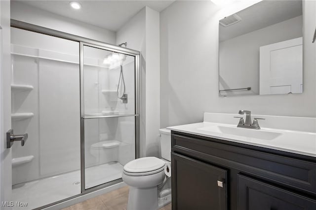 bathroom featuring visible vents, toilet, a stall shower, tile patterned floors, and vanity