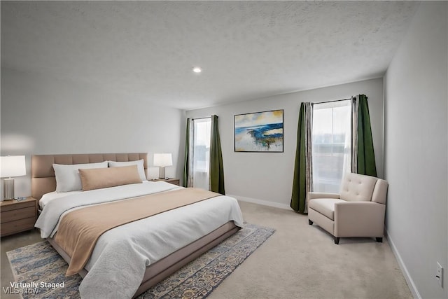 bedroom featuring multiple windows, light colored carpet, and baseboards