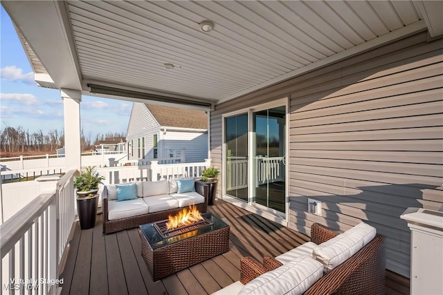 deck with an outdoor living space with a fire pit