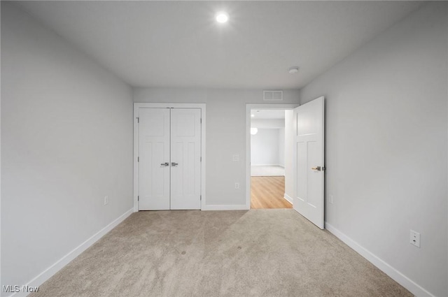 unfurnished bedroom featuring a closet, carpet flooring, baseboards, and visible vents