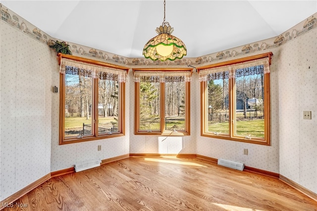 unfurnished sunroom featuring visible vents, radiator, and lofted ceiling