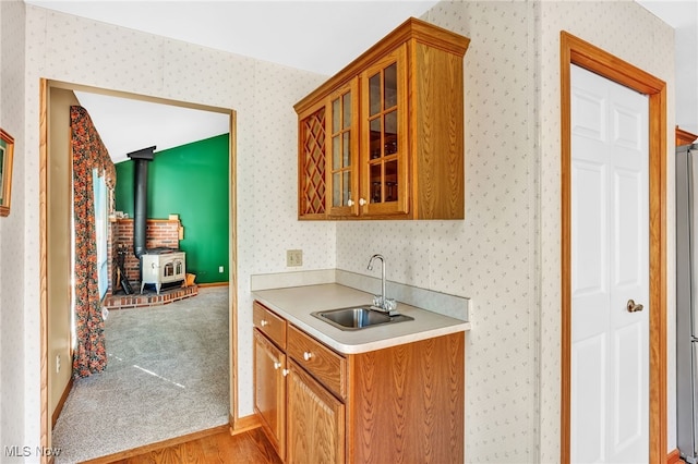 bar with wallpapered walls, a wood stove, wet bar, and a sink